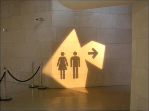 Light and shadow cast onto wall showing toilet wayfinding information