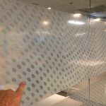 Large perforated window frosting on office wall
