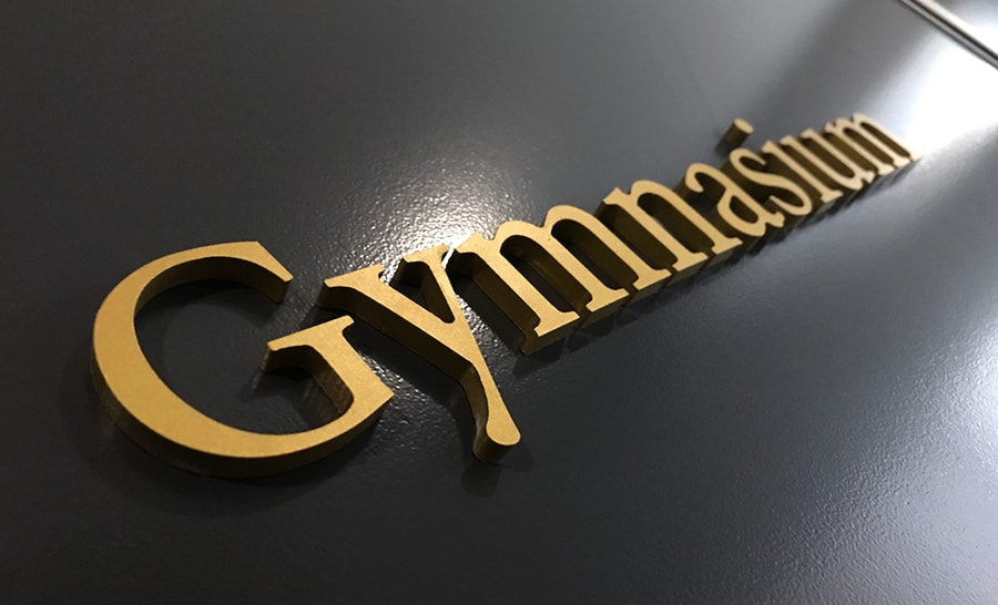 Gold gymnasium signage on black wall