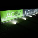 AC EV Electric Vehicles. Large, wall spanning green sign