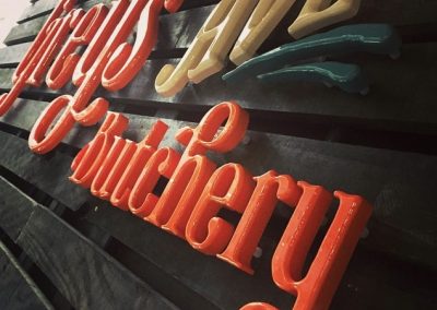 Grey's Butchery orange acrylic signage