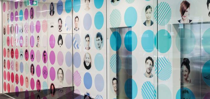 Printed wall art, with abstract colours and headshots of team members