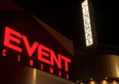 EVENT Cinemas red and white illuminated signage shown at night