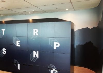 Black cubicle wall with white letters written