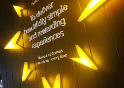 Yellow backlit arrows surrounding company mission statement