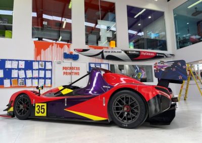 Radical racecar with purple, yellow, and black livery, freshly wrapped
