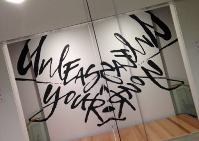 Sign saying Unleash Your, written on a mirror in graffiti text