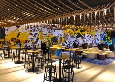 Indoor restaurant seating area with wall spaning abstract mural wrap across wall